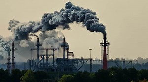 Smokestacks billowing thick clouds of exhaust as the factory works around the clock..