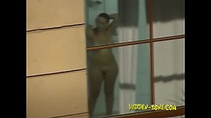 A girl washes in the shower, and we see her through the window