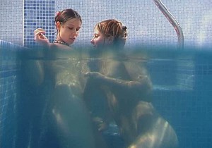 Seductive brunette lesbians tickle their snatches under water in pool