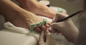 Woman getting pedicure in beauty salon