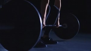 Military overhead shoulder push press. Young female loaded barbell lifting.