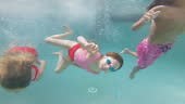 Children diving into a swimming pool and enjoying swimming on a...