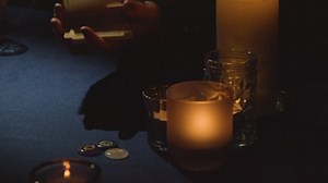 Free stock video - Close up of woman laying out cards for tarot reading on candlelit table 1