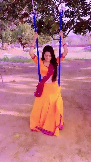 Swinging in Traditional Dress: A Colorful Outdoor Scene