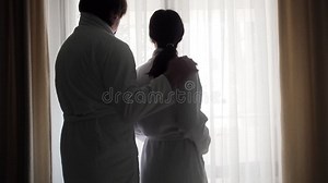 Scène Dans L'hôtel. Couple Le Matin à La Fenêtre Dans La Chambre De L'hôtel. Le Mari Approche Et Embrasse La Femme Clips Vidéos - Vidéo du maison, matin: 239527205