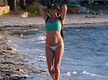 Suzi Taylor takes casual stroll along the beach in G-string bikini