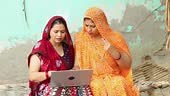 Rural indian women using laptop or learning computer together....