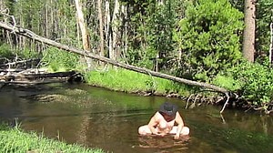 Bathing naked in the stream.
