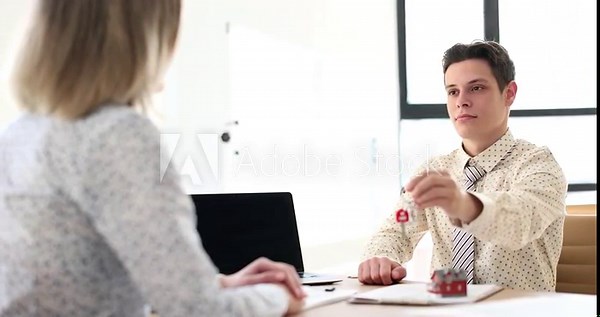Real estate agent gives a woman the keys to the house