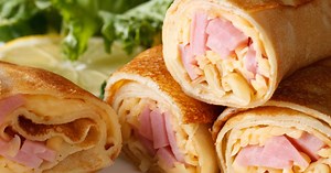 Як приготувати тоненькі млинці без грудочок, які виходять ідеальними: рецепт з начинкою з сиром та ковбасою