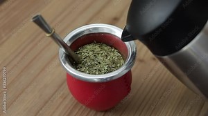 Man making yerba mate tea. Close up pouring hot water into traditional Mate cup. Kettle pours hot water into a red mate to make a delicious steaming yerba mate infusion, a traditional South American, Stock Video