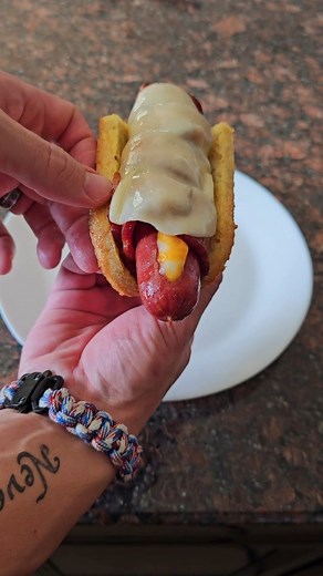 Bacon Wrapped Cheese Stuffed Hot Dog with a Carnivore Bun Ingredients: For the Carnivore Bun: · 2 tbsp Butter, Melted · 2 Eggs · 1/2 cup Pork Rinds, Ground · 1/4 cup Shredded Parmesan Cheese For the Hot Dog: · 2 Hot Dogs · 5 Strips of Bacon · Cheese (for stuffing) · Cheese (for topping) Instructions: Prepare the Carnivore Bun: · Preheat your oven to 400 degrees F. · In a bowl, mix together the melted butter, eggs, ground pork rinds, and shredded Parmesan cheese. · Pour the mixture into a silicon