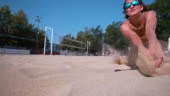 Female volleyball athlete dives for a point during a summer...