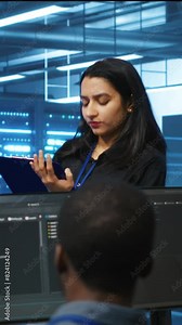 Vertical video Manager overseeing server room, walking around with checklist on notepad, troubleshooting hardware. Supervisor doing inspection in server hub, monitoring energy consumption across rigs