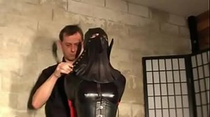 Woman bound in leather and hooded