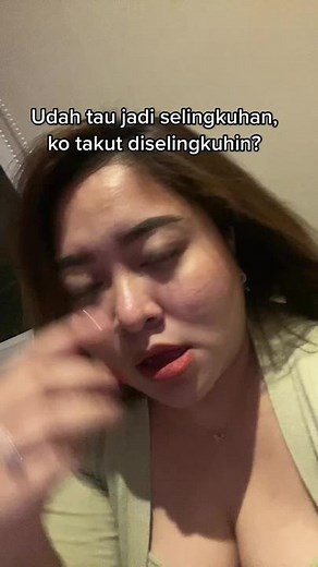 Person in Green Top and Necklace in Indoor Setting