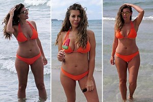 Imogen Thomas puts on a busty display in orange bikini after admitting she thinks her boobs are 'too big'