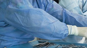 Preparation for the surgery. Surgery tools. Multiple surgery tools on the table in operating room. Scrub nurse hands in rubber gloves. Modern medical concept.