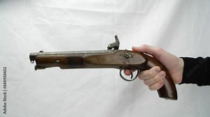 Hand holding and pretending to fire a Antique Colonial Percussion Pistol, believed to be local militia issue circa 1850. This is a single shot muzzle loading holster pistol with a percussion lock