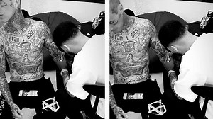 Travis Barker adds a 'Survivor's guilt' cursive script tattoo on his forearms