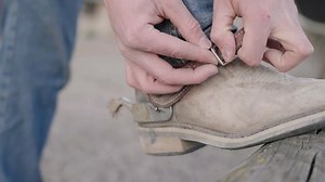 Cowboy put on spurs on boots close-up 4K