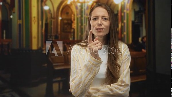 Woman pointing finger forward in church building with folded arms and open mouth while speaking; assertive instruction. vídeo de Stock