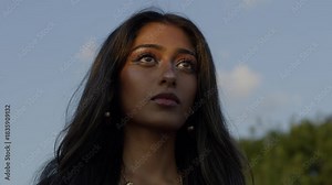 Portrait of a woman gazing thoughtfully at the sky outdoors