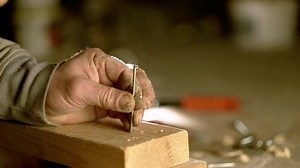 clip-1026836222-man-hammers-nail-into-tree-old-hammer