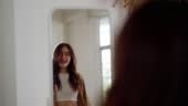 Young beautiful asian woman happily dressed in front of the mirror....