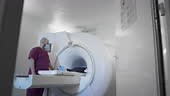 The doctor conducts an MRI or PET scan of a patient in a modern...