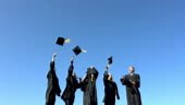 Group of graduates tossing graduation caps into sky, slow motion, 300...