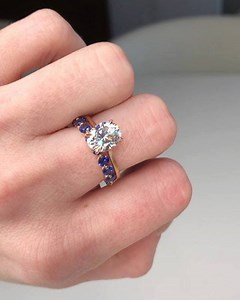 The Elle Solitaire with a 9x7mm F1 Oval Moissanite in 18k Recycled Rose Gold alongside #TheJennieBand (large) with #BlueSapphires 💙💍 #TheElleSolitaire | The True Gem