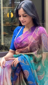 Comment “LINK” to order 💜💙 A saree that doesn’t just turn heads — it owns the room. This vibrant drape flows in a stunning ombré from royal blue to deep purple, sprinkled with intricate golden paisley motifs that glow beautifully under light. The sheer, lightweight texture gives it that dreamy, floaty movement every woman loves for festive evenings. The blouse? Pure elegance. Crafted in rich royal-blue silk, designed with a deep neckline and delicate lace trimming along the edges and sleeves —
