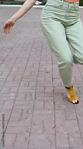 Woman dancing high heels outdoors. Close-up of female legs. Vertical video.