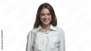 Close-up of attractive female brunette in white collar shirt, raising eyebrows and gasping surprised, feeling happy and glad about something, standing over studio background