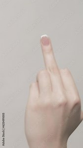 Vertical video. Middle finger. Rude gesture. Woman hand showing set of 3 impolite signs offensive behavior isolated on gray free space background.
