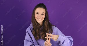Hashtag. Woman showing hashtag symbol with fingers hands, likes tagged message, popular viral social media content, sign to follow internet online trends. Girl isolated on purple studio background.