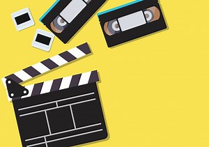 Movie clapper and video cassette tapes on yellow background | Premium Vector