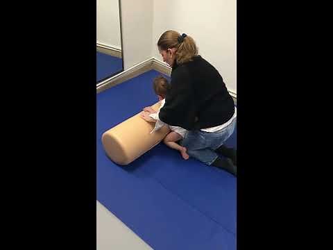 NDT-Bobath therapy to a quadriplegic dystonic child on a roll
