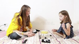 Two Sisters Play Checkers on the Bed and Eat French Fries Stock Footage - Video of smiling, girl: 236612434