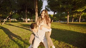 Young man giving piggyback ride to his girlfriend in a park