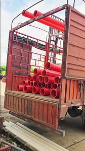 Forklift Efficiently Unloads Bright Red PVC Pipes from a Truck