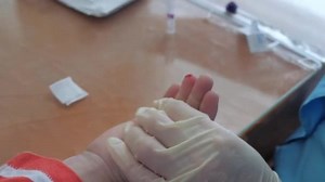 Nurse takes blood from a finger of child in medical laboratory. Blood sampling from the finger into the test tube for a general analysis. finger prick blood