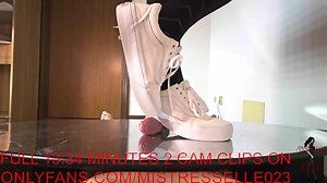 Mistress Elle flattens her slave's cock with her vans