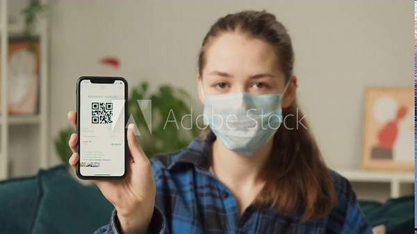 Woman showing on phone vaccination passport with qr code, international coronavirus covid 19 vaccine certificate on mobile device, green zone.