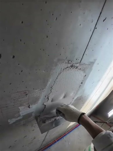 the process of patching white cement mixture on the walls of a building that has holes #popular
