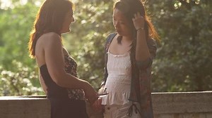 Two best female friends talking chatting at the sunset in the park