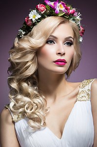 Beautiful blond girl in the image of a bride with flowers in her...