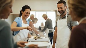 Download Cheerful Volunteers Serving Nutritious Meals at a Community Food Bank. for free