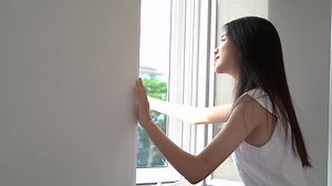 Beautiful asian woman open windows after wake up and look out resting